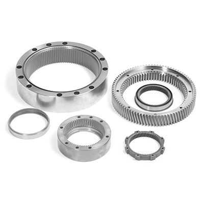 Mehrere präzisionsgefertigte Hohlräder aus Metall, angeordnet auf hellem Hintergrund